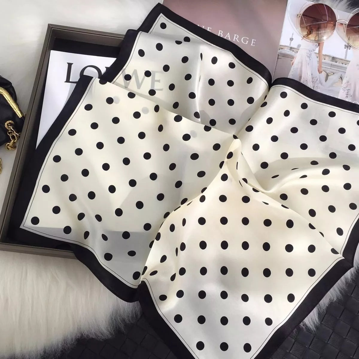 Cream white silk scarf with black polka dots draped in soft folds