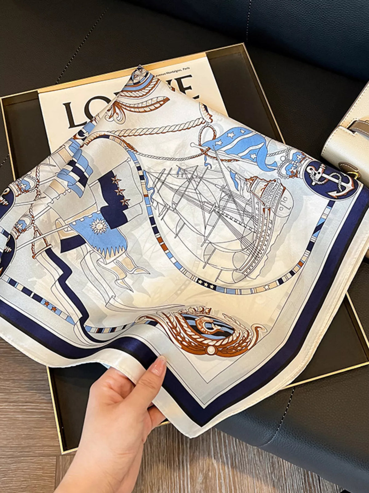Ivory scarf held open to show sailing ships, blue flags, and a navy border.