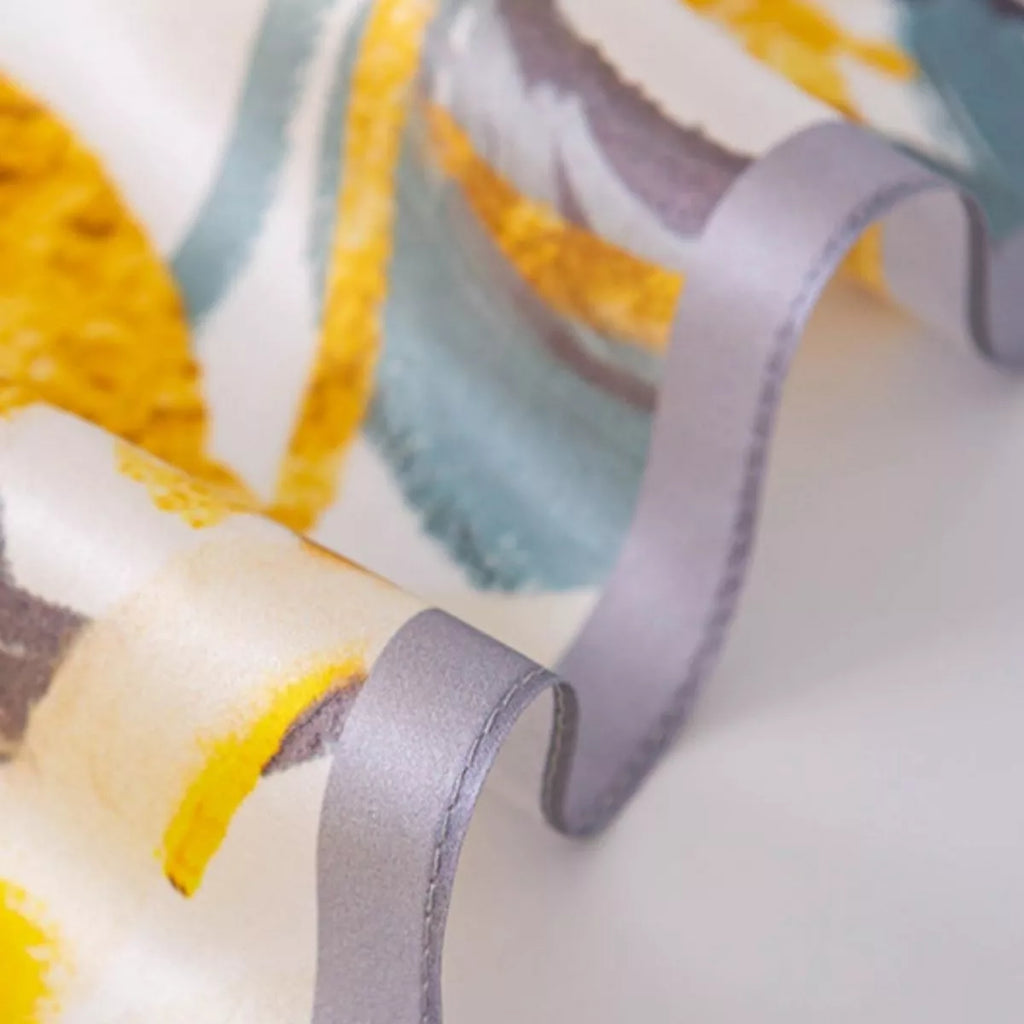 Close-up of the scarf’s gray stitched edge and yellow floral print.