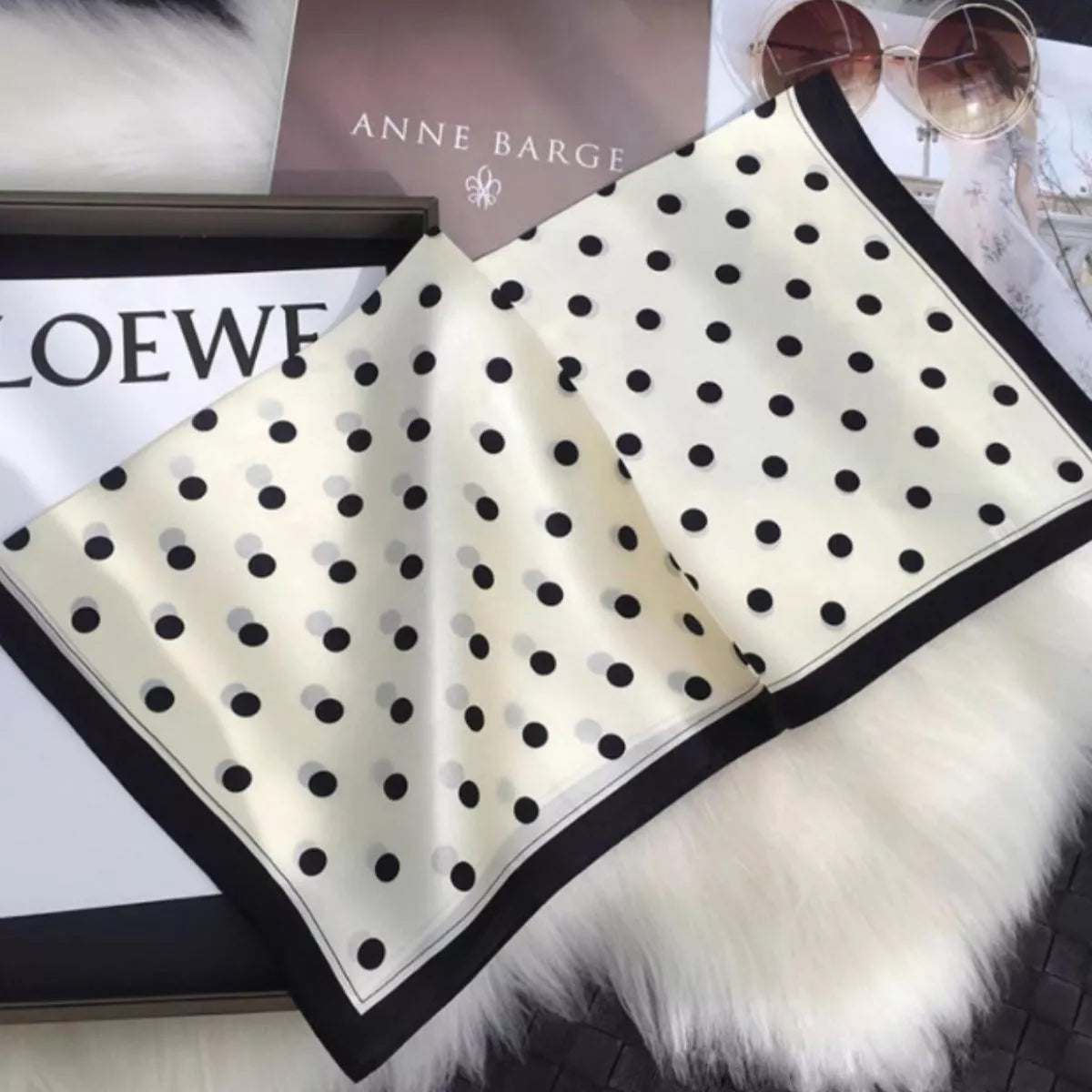Cream white polka dot silk scarf spread out to show its black border
